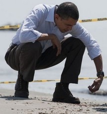 Barack Obama prend dans sa main des boulettes de fuel