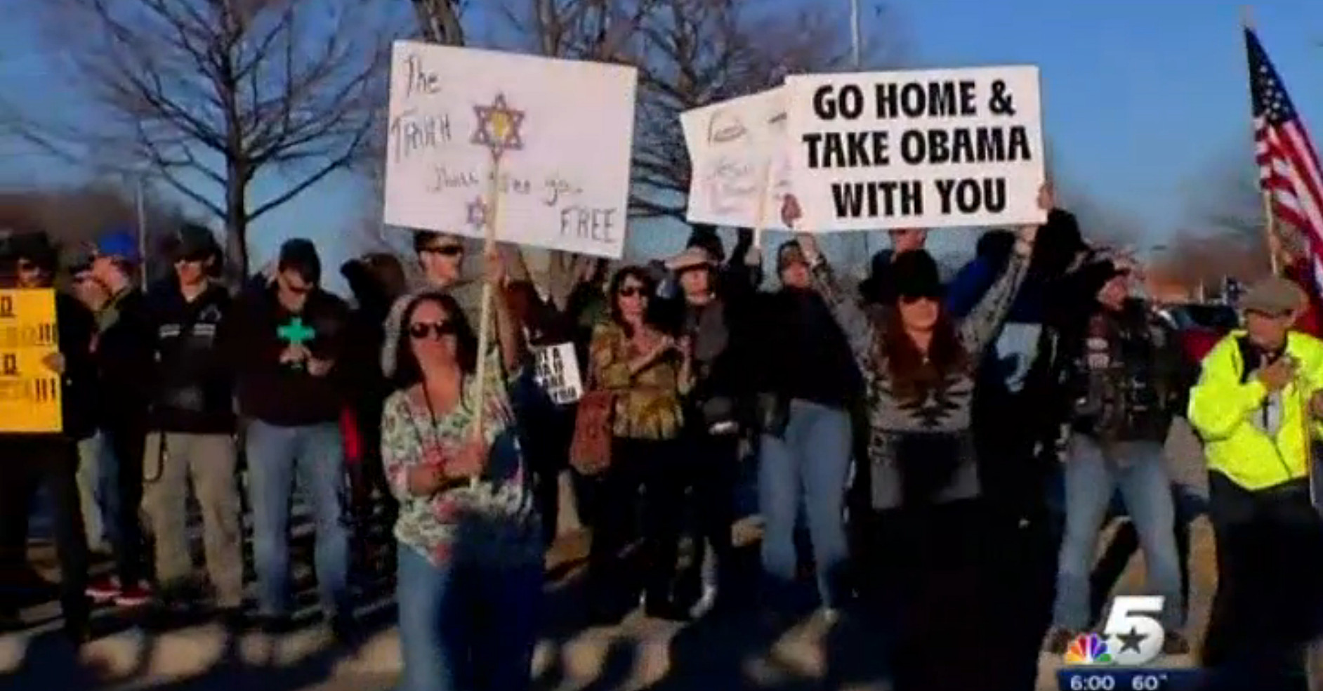 Capture d’écran du reportage de la NBC montrant une femme avec une pancart qui dit : « Rentrez chez vous et emportez Obama avec vous »