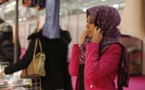Une jeune femme essaie un foulard le 3 avril 2015, dans les allées de la rencontre annuelle des musulmans de France au Bourget Le shopping musulman a son temple au Bourget, le temps d'un week-end